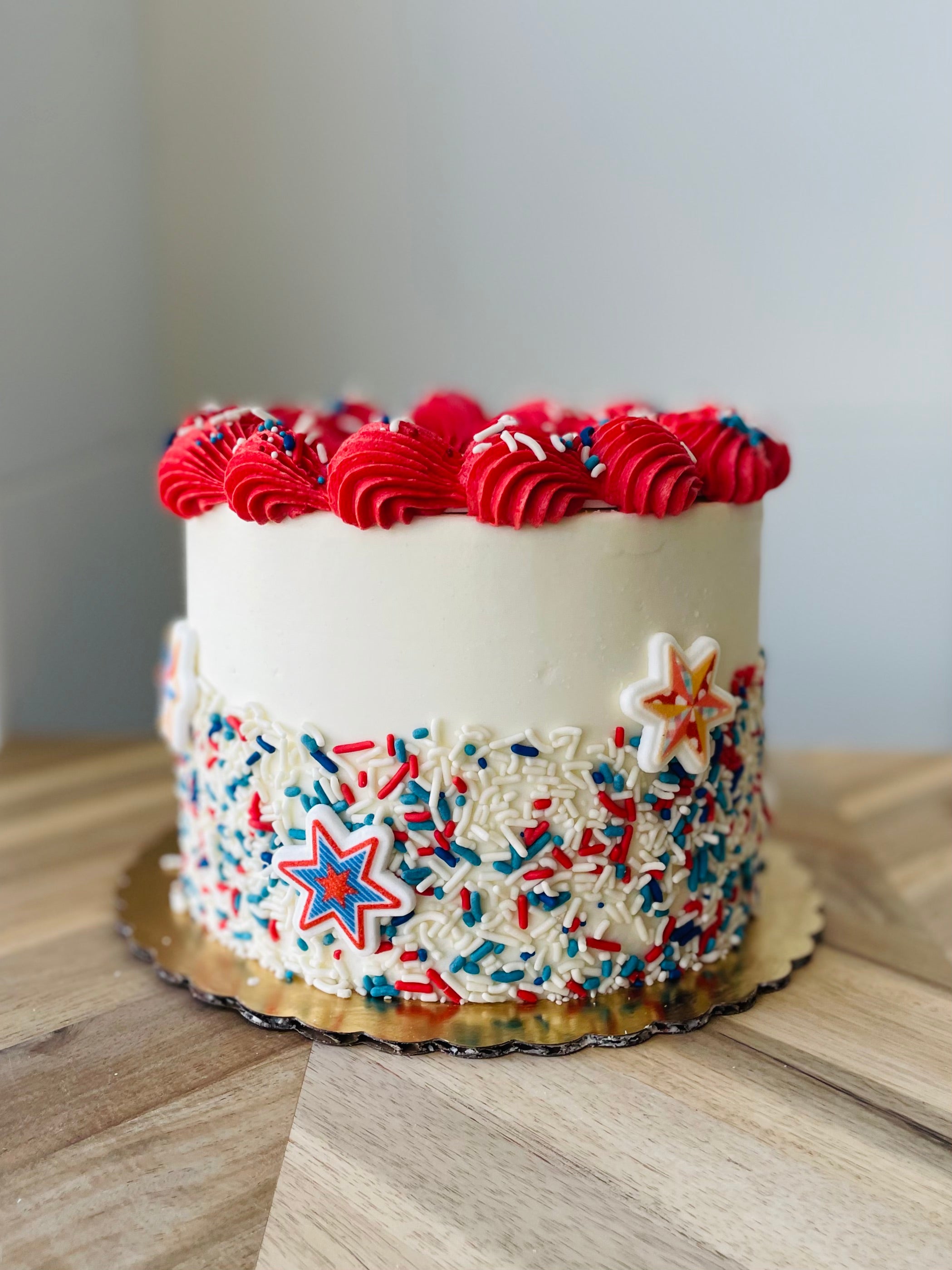 Decorative cake with red, white, and blue icing on a wooden surface