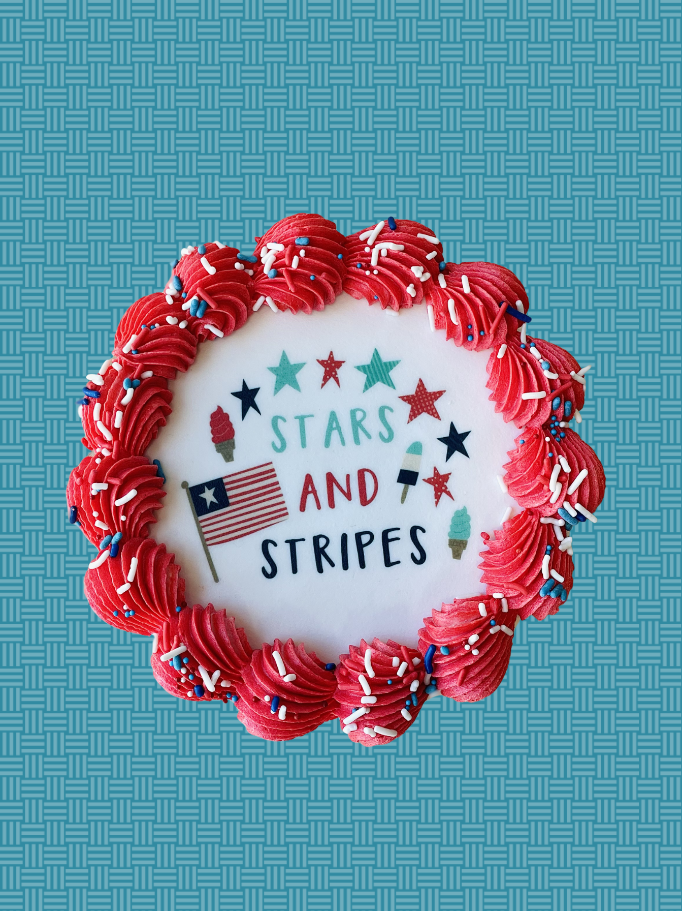 Cupcake with red frosting, stars, stripes, and ice cream cones on a blue textured background